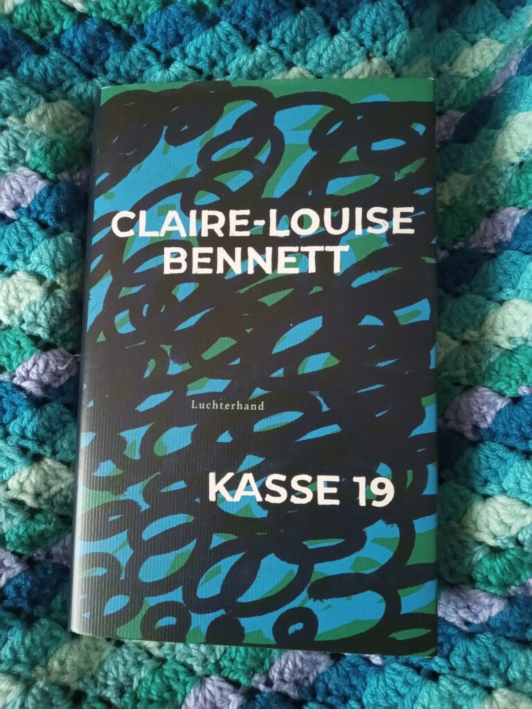 Das Buch Kasse 19. Auf dem Schutzumschlag sieht man blaue, schwarze und grüne Kritzeleien, auf der Titel, Verlag und Autorin in einfach gehaltener Schrift angeordnet sind.