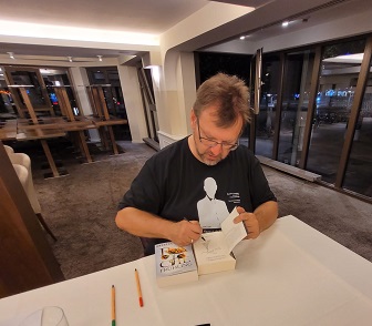 Der Autor beim Signieren eines Buches.
